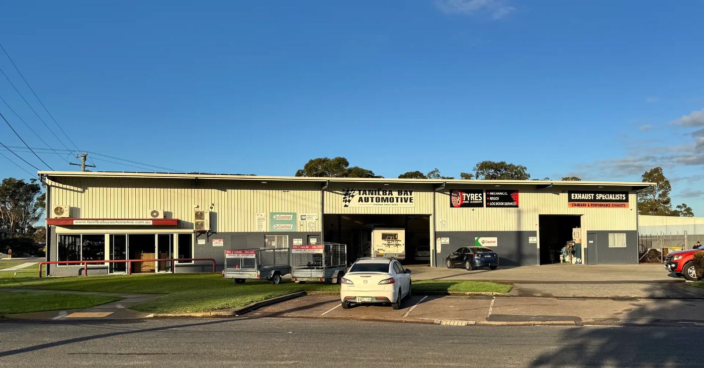 The Tanilba Bay Automotive workshop exterior with trailers and customer parking